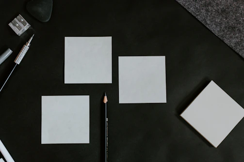 A black table topped with white cards and a pencil