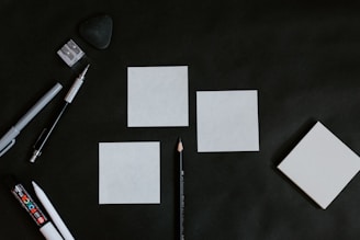 A black table topped with white cards and a pencil