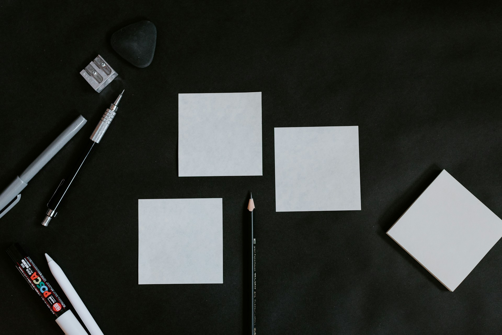 A black table topped with white cards and a pencil