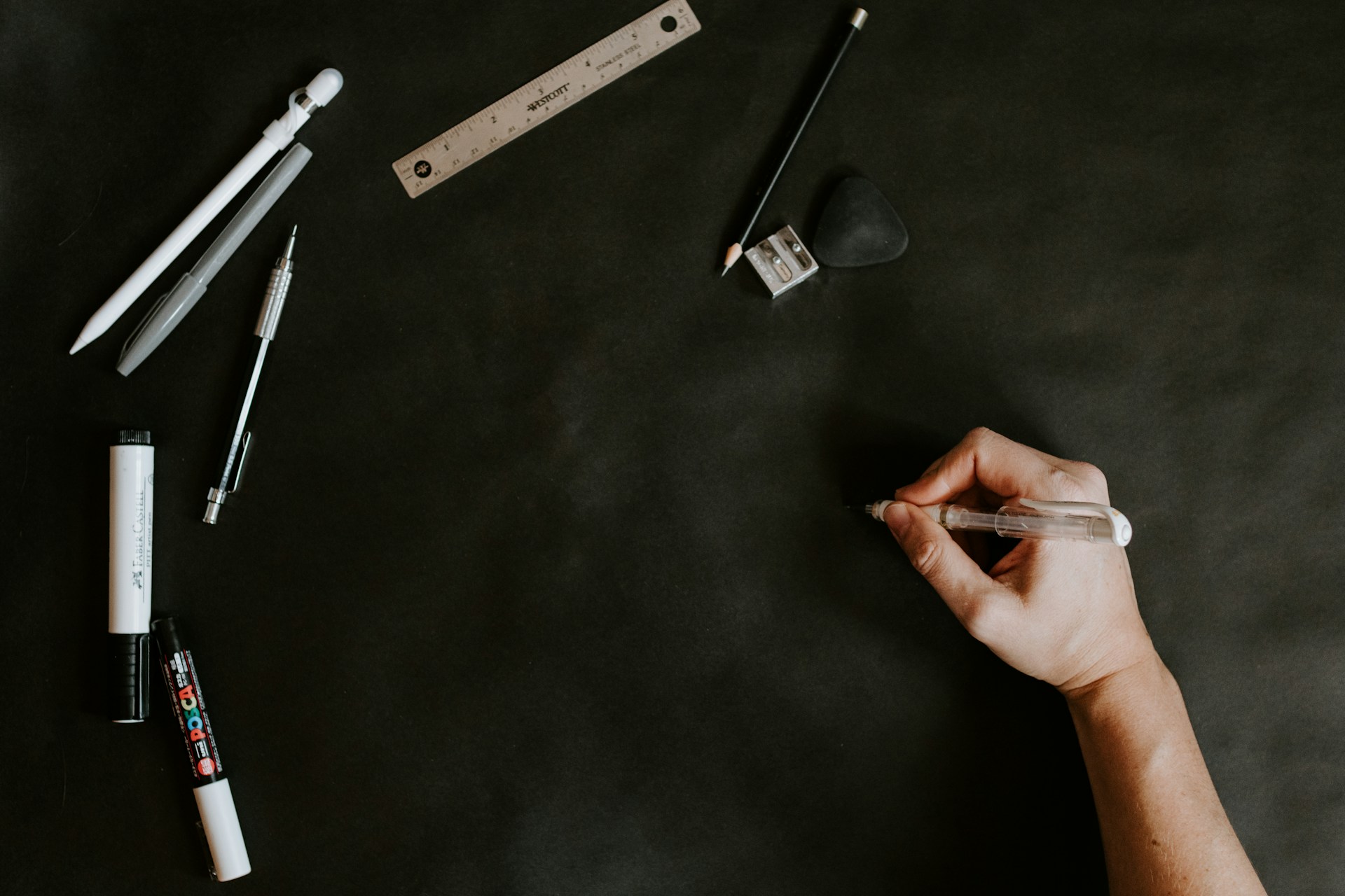 A person writing on a blackboard with pens and markers