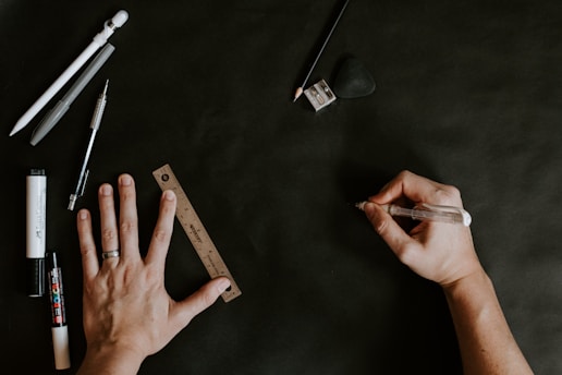 A person's hand holding a pen over a piece of paper