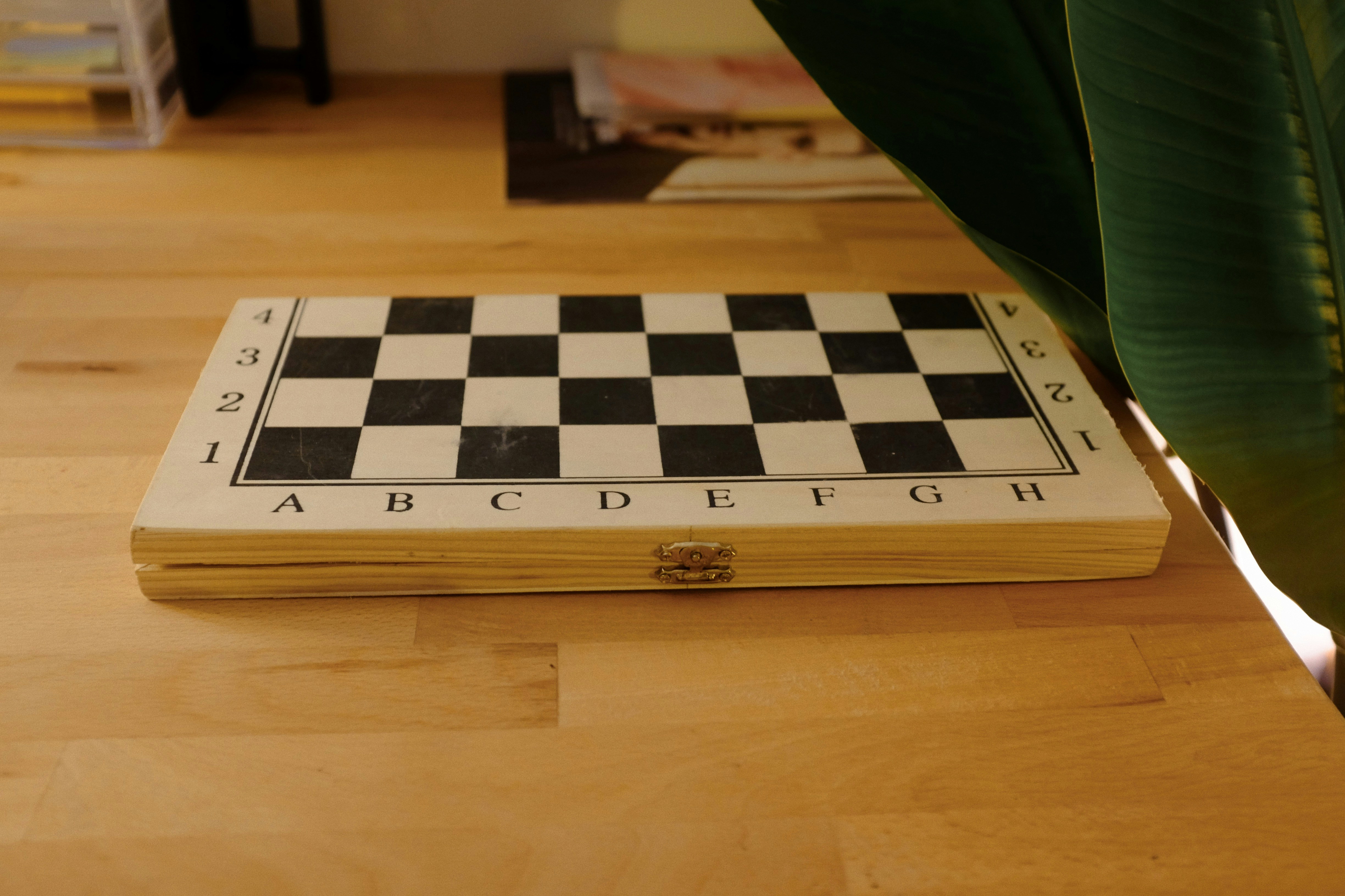 A black and white checkered board sitting on a wooden table