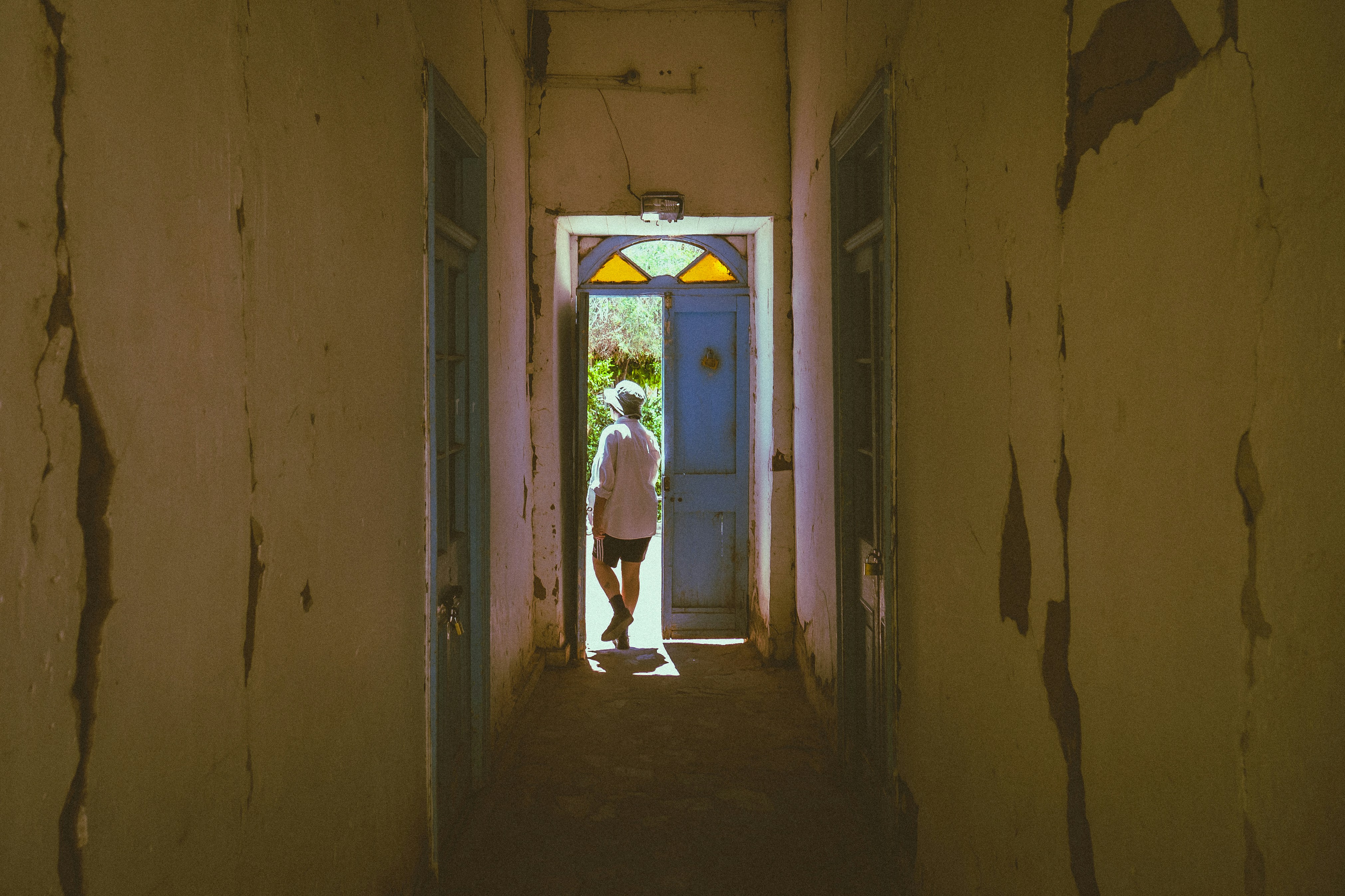 A person standing in a hallway with a door open