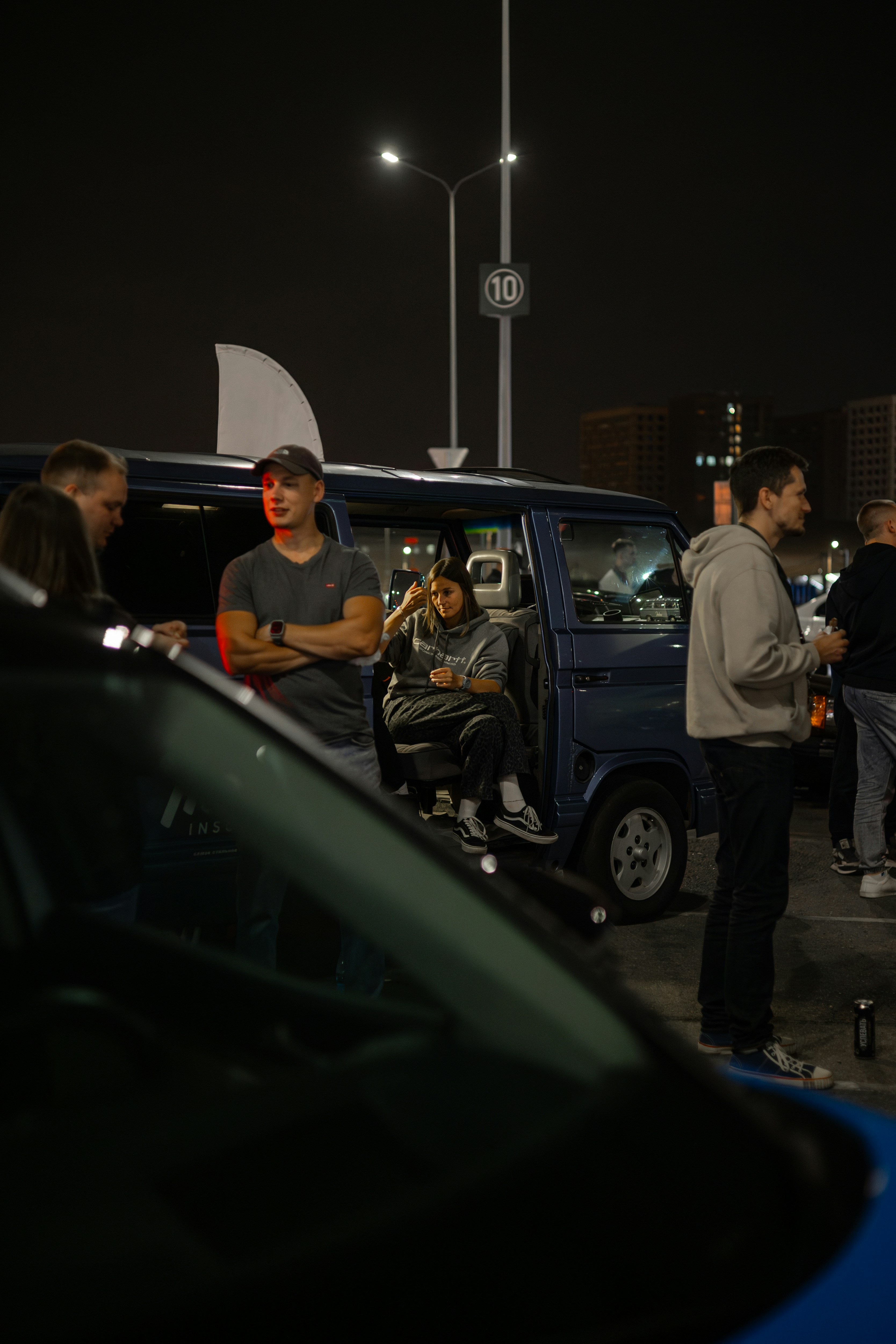 A group of people standing around a blue van