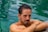A man with his arms crossed sitting in a pool