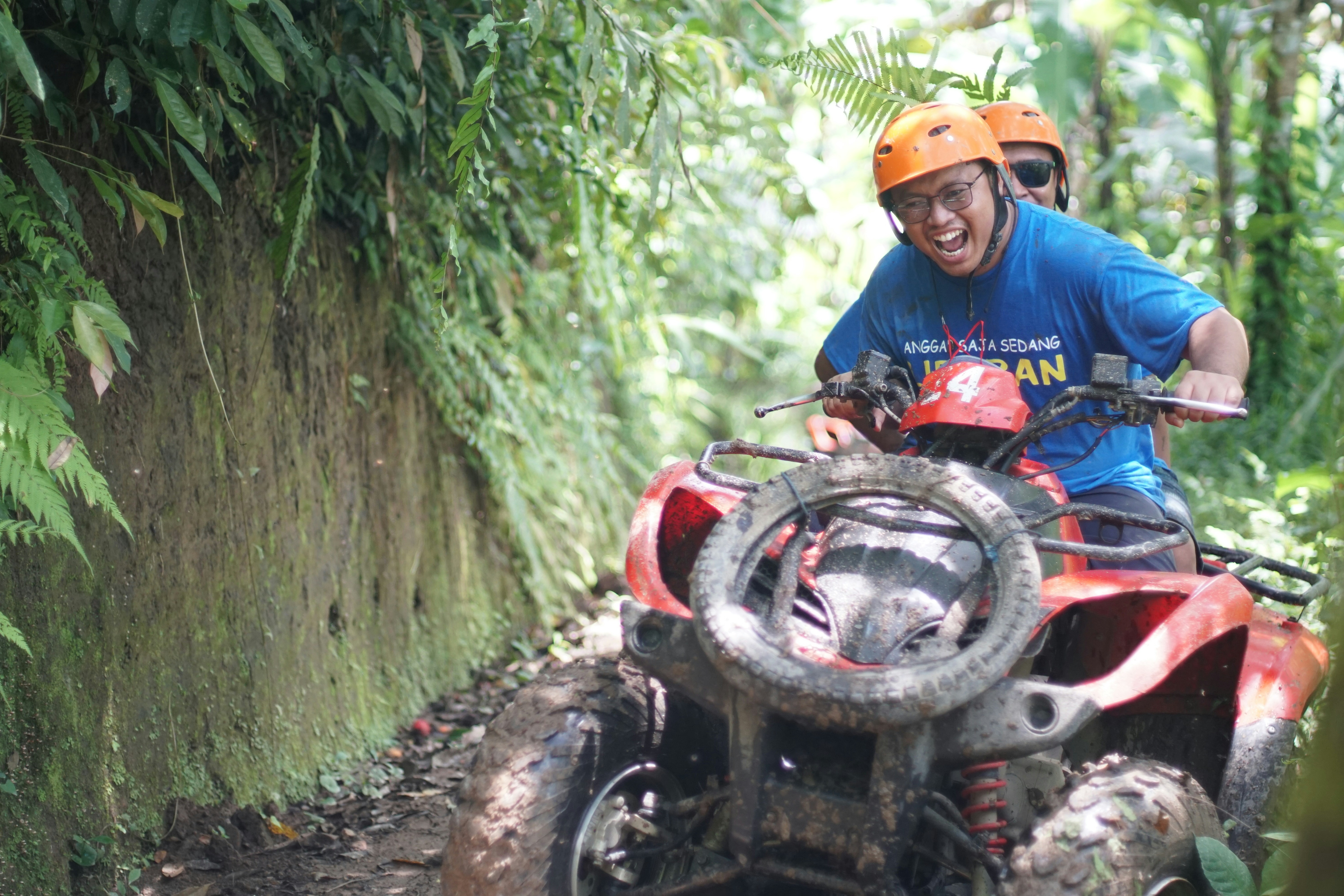 A man riding on the back of a red four wheeler