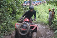 A man riding on the back of a red four wheeler