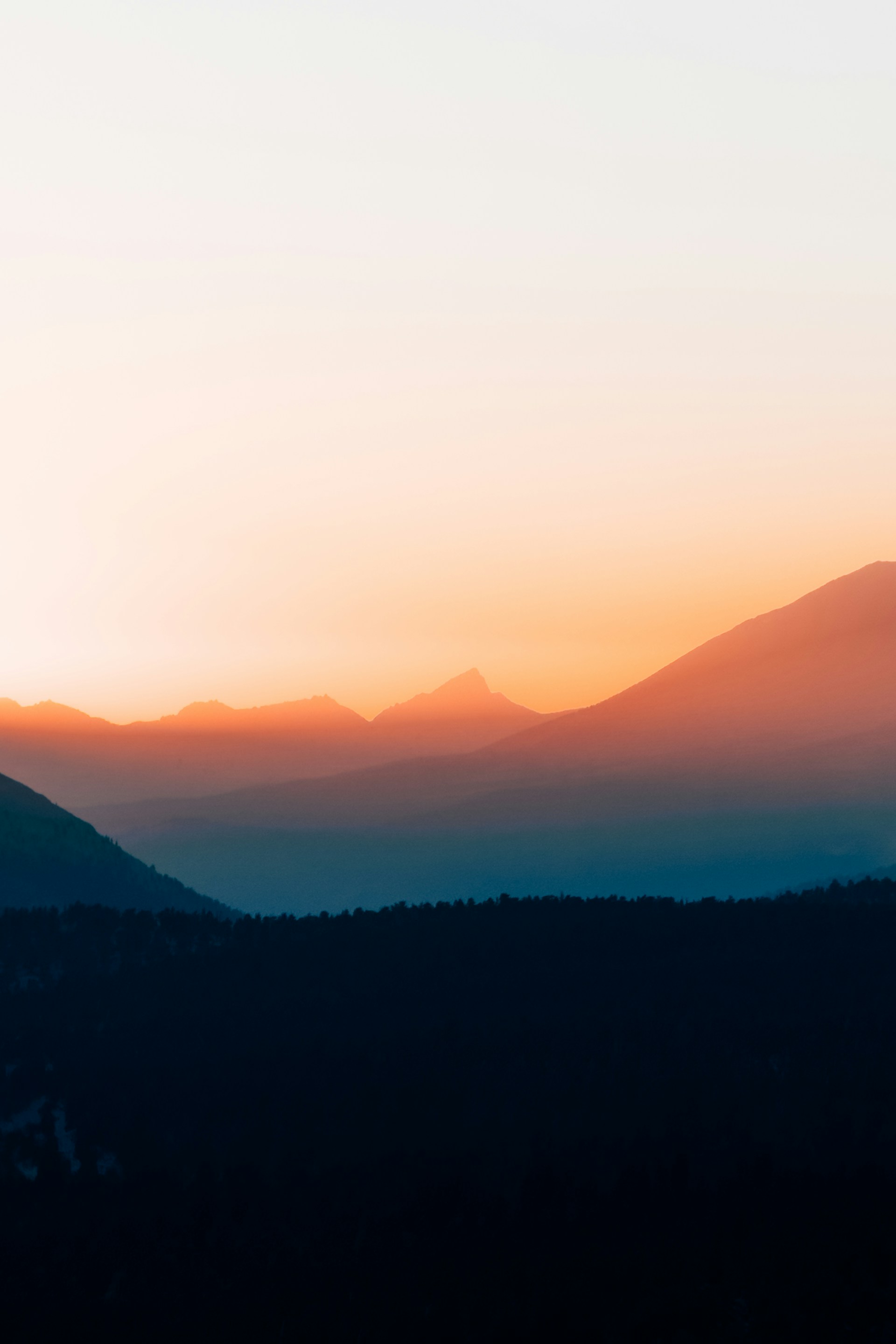 The sun is setting over a mountain range