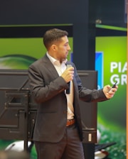 A man in a suit speaking into a microphone