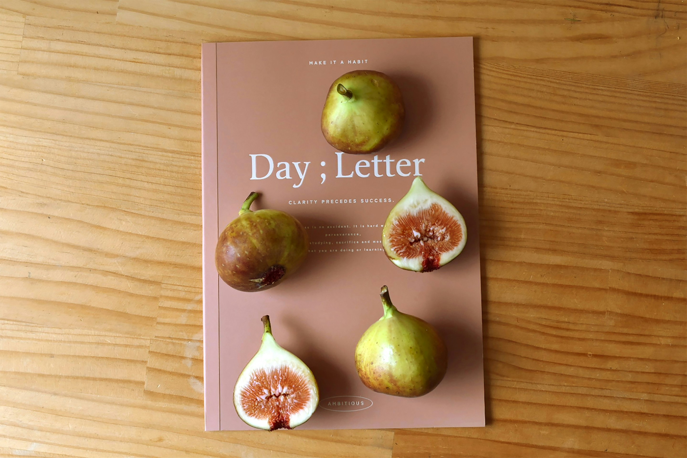 A book on a wooden table with some fruit on it