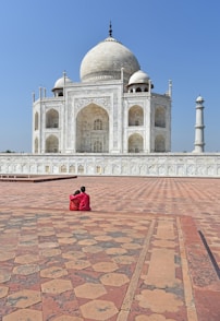 A person sitting on the ground in front of a building