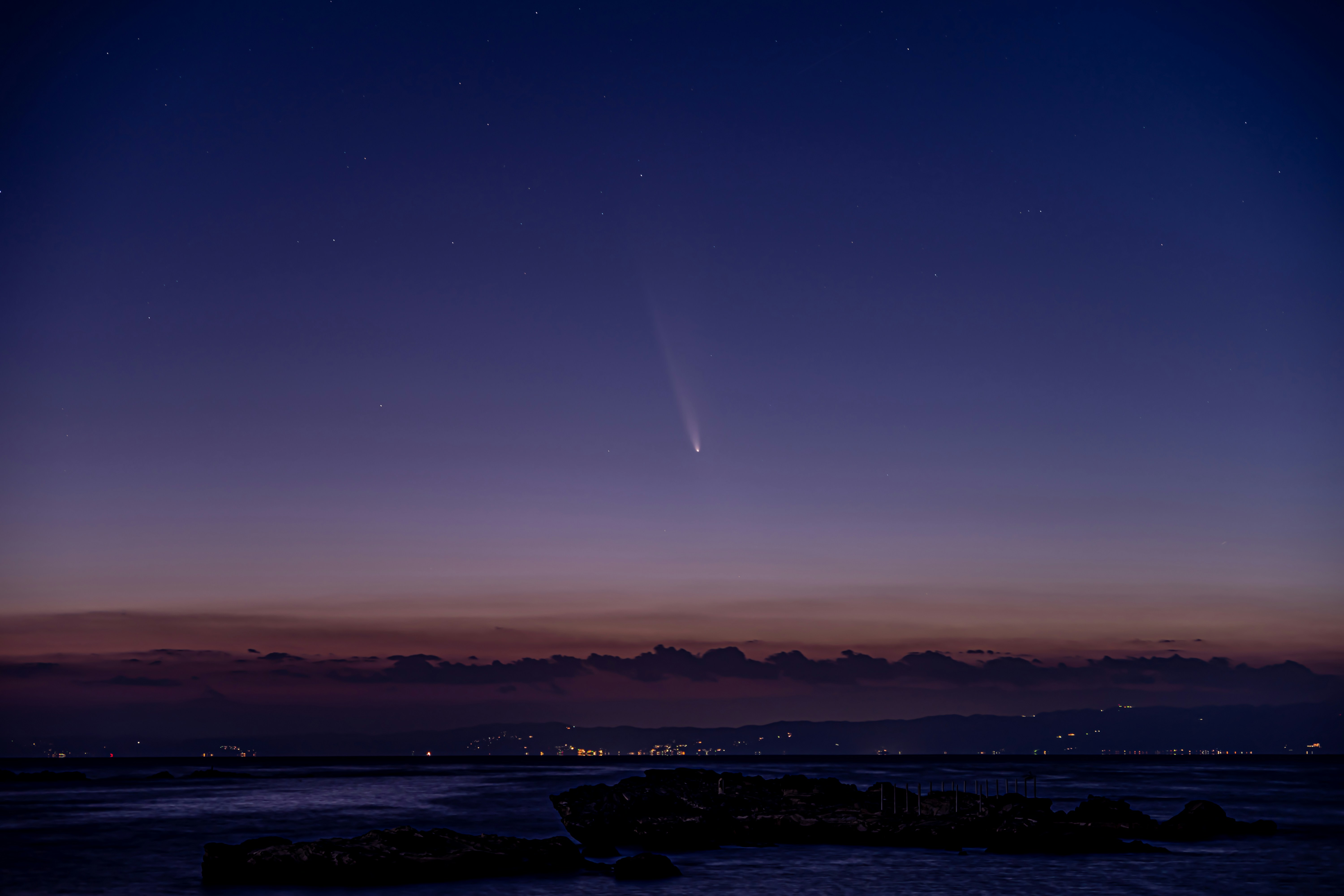 A view of the night sky with a plane in the distance