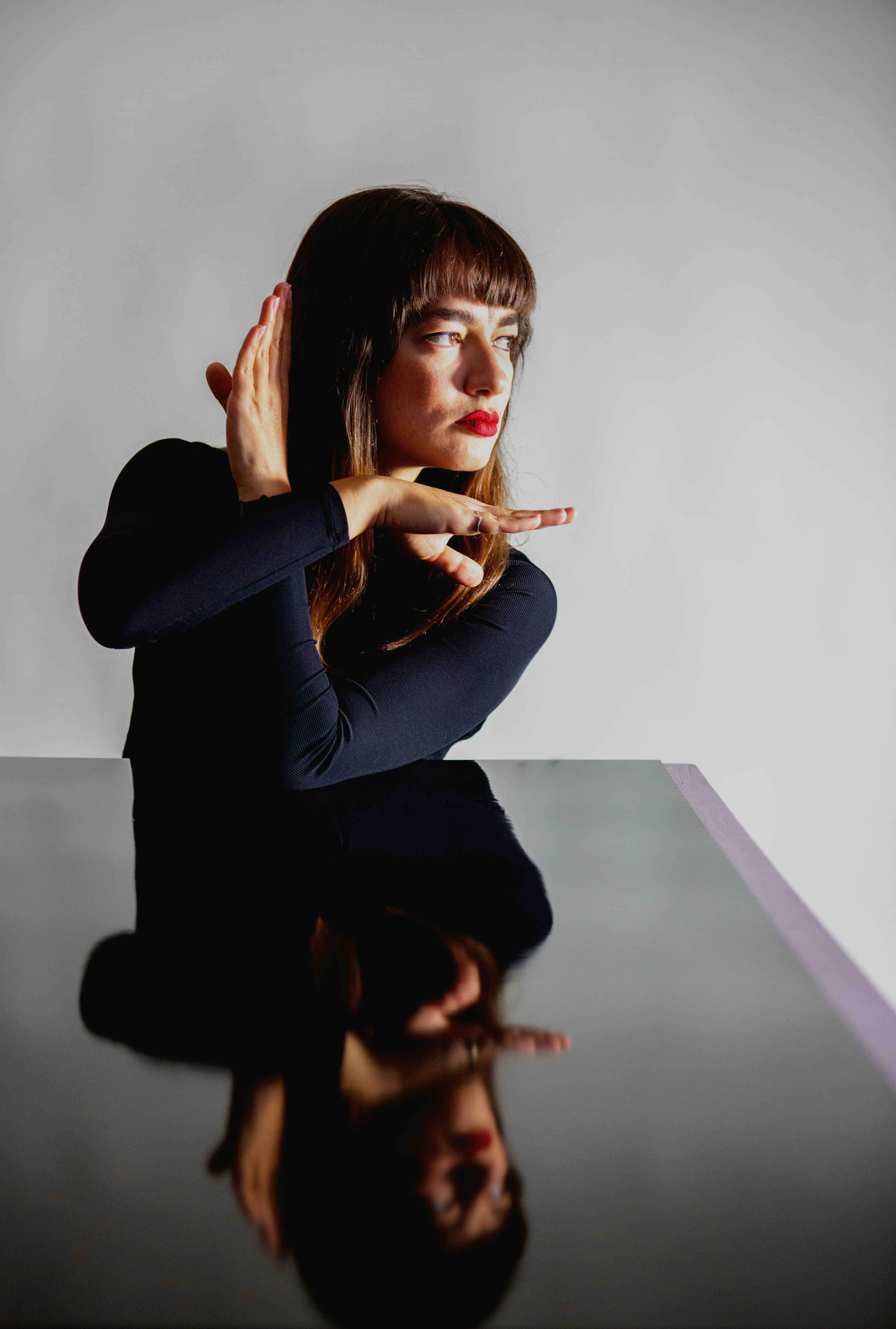 A woman sitting at a table with her hand on her face