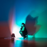 A person sitting on a floor in front of a wall