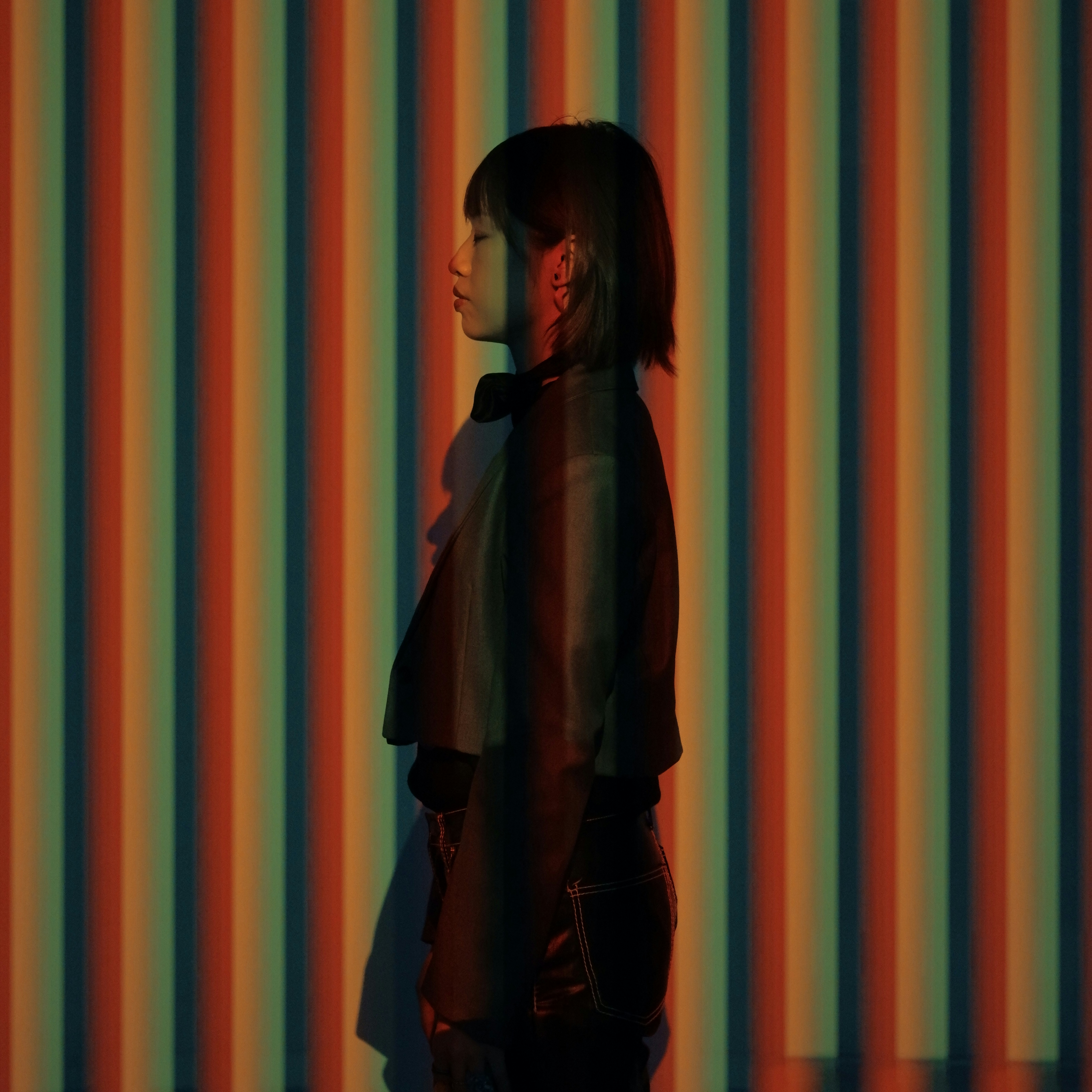 A woman standing in front of a striped wall