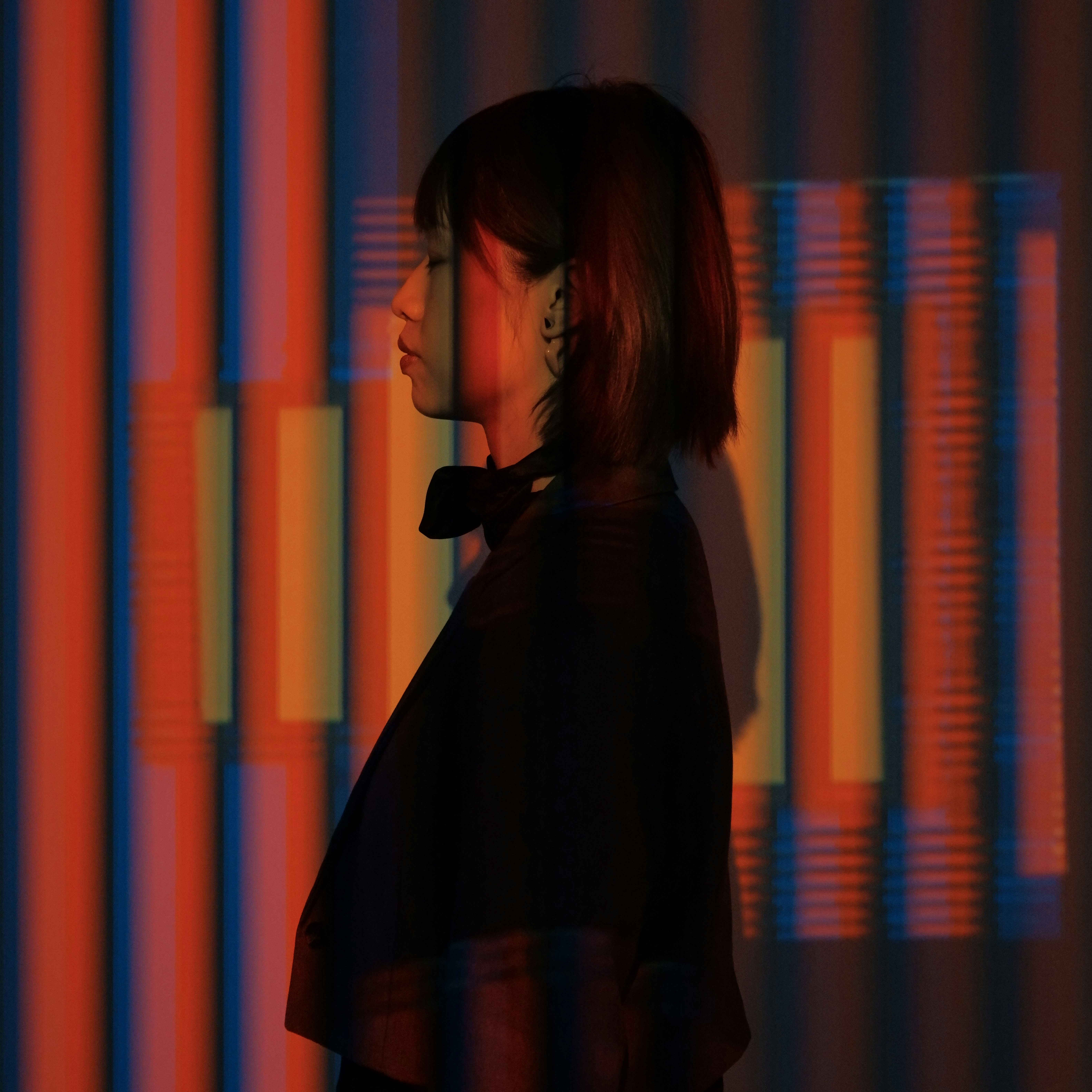 A woman standing in front of a colorful wall