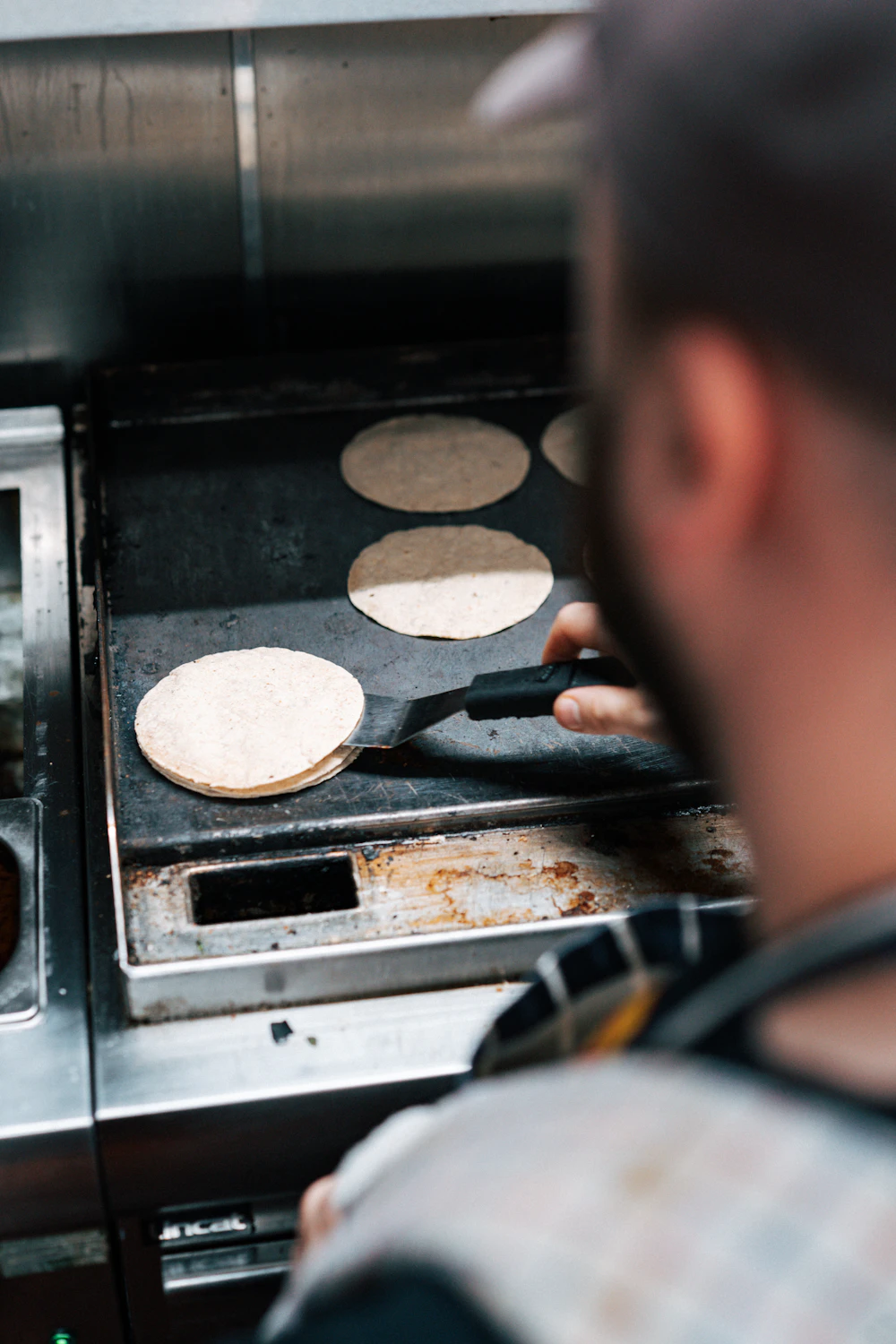 A cook preparing food on a commercial flat-top grill