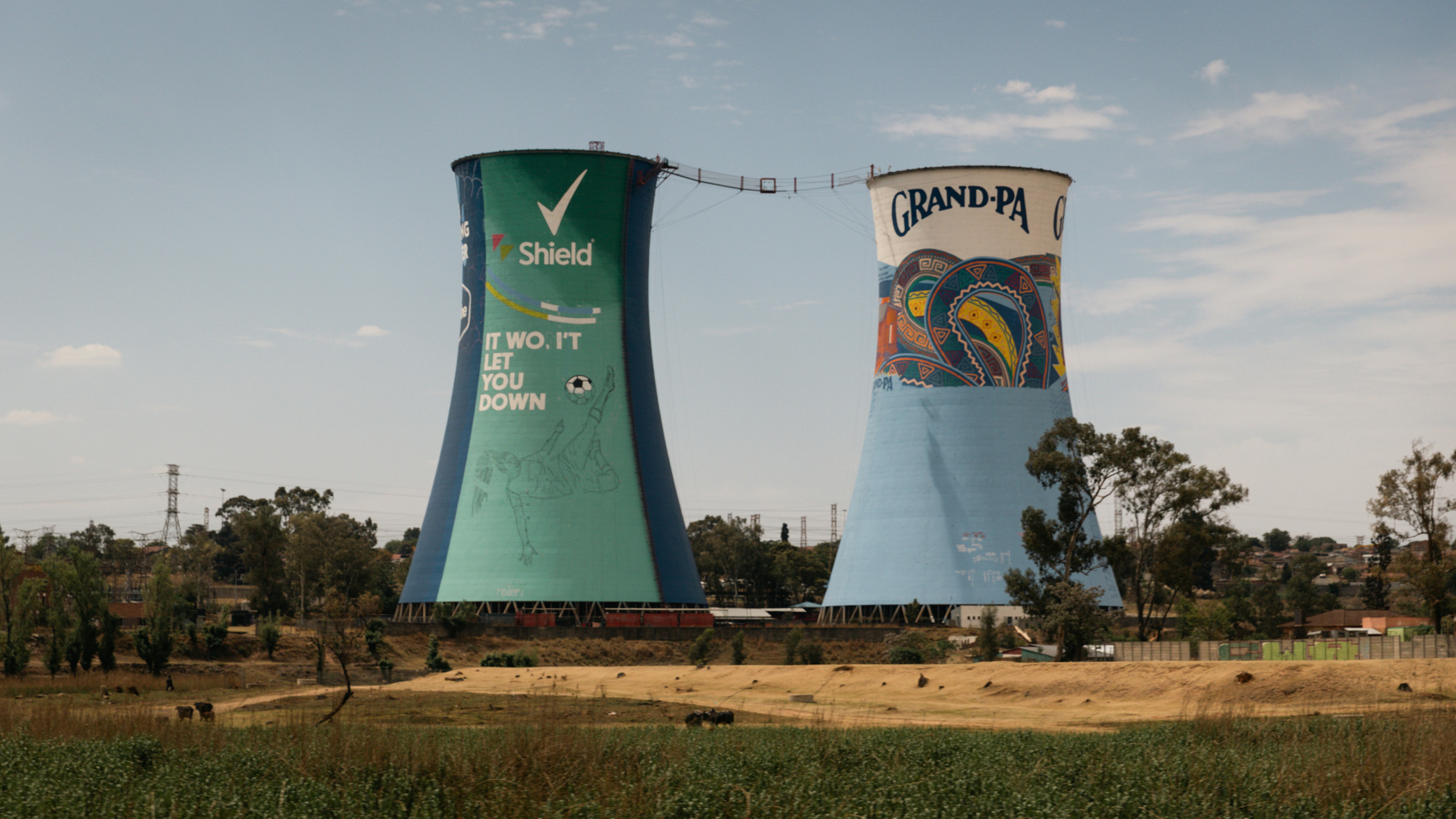 A couple of tall towers sitting in the middle of a field