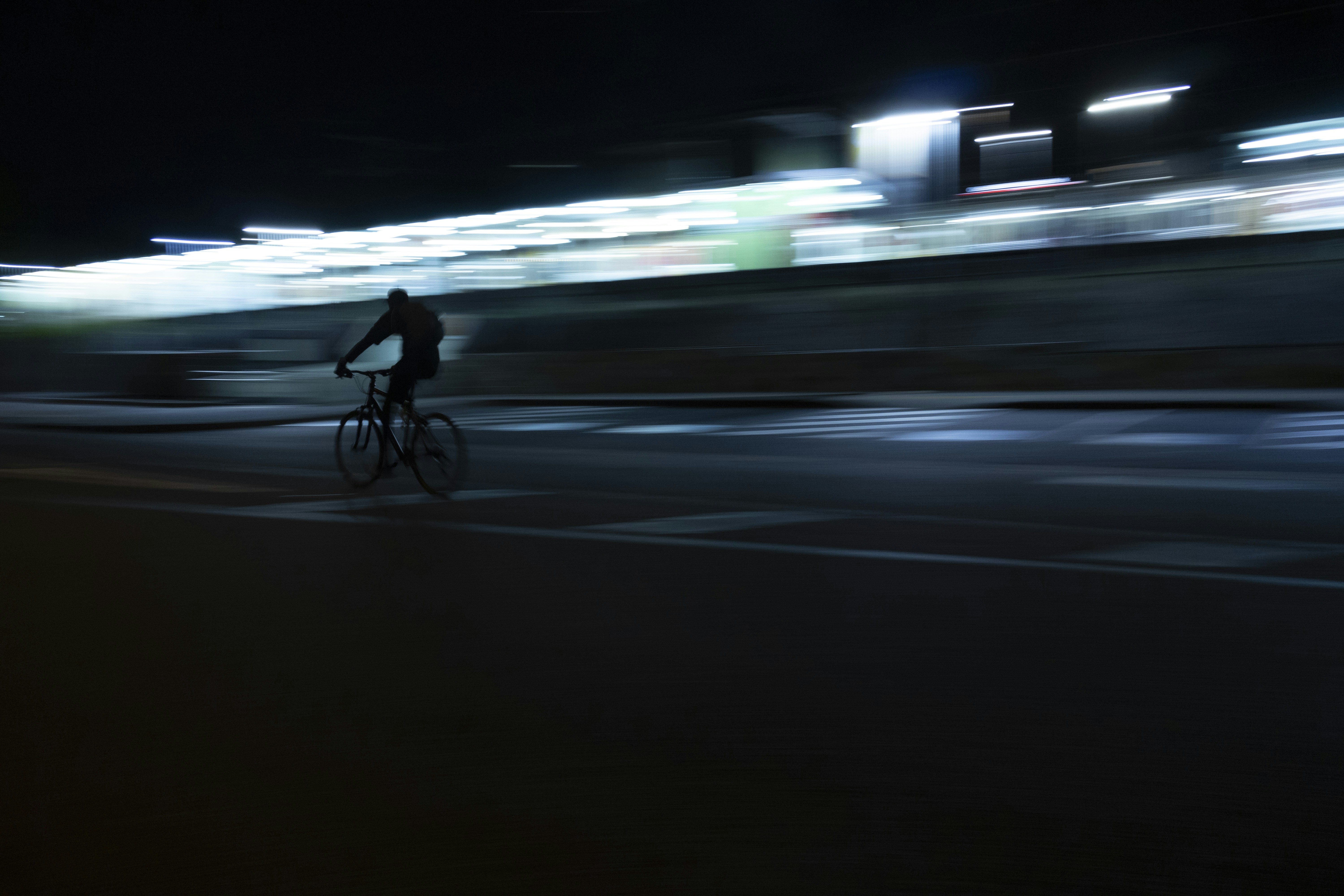 A man riding a bike down a street at night