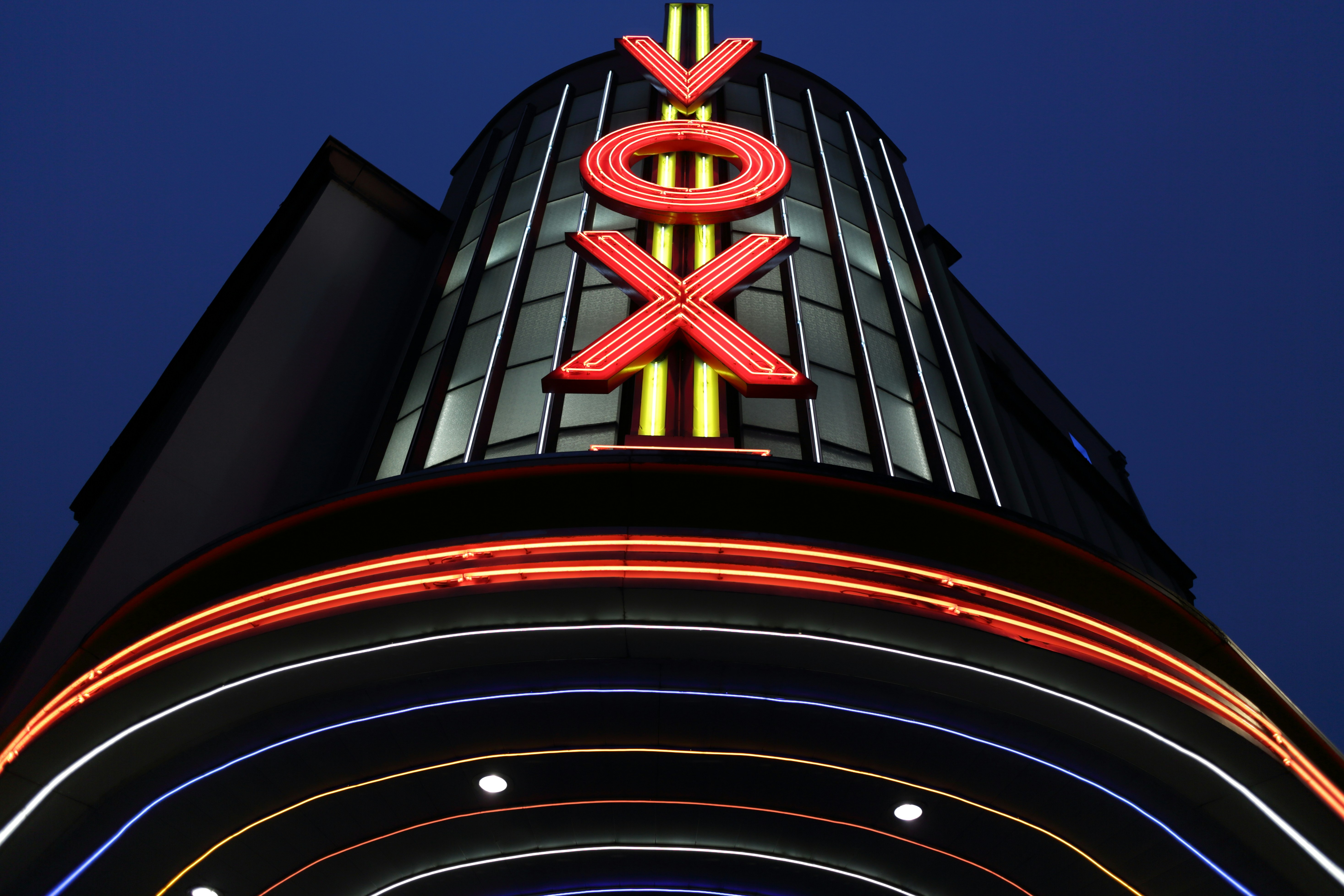 A very tall building with a neon sign on top of it