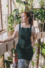 A woman standing in front of a window in a greenhouse