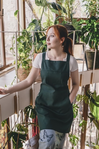 A woman standing in front of a window in a greenhouse