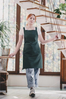 A woman in a green apron is walking down the stairs