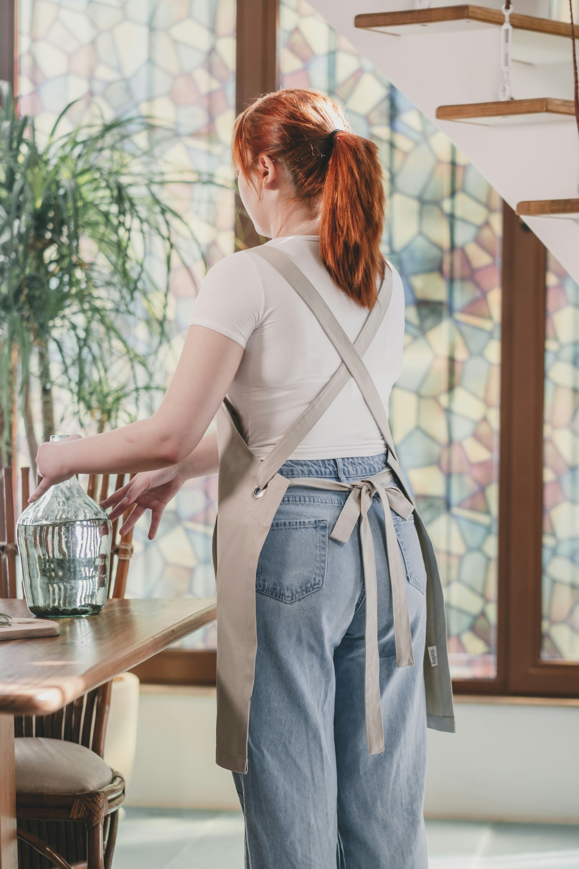 Eine Frau, die mit einem Glas in der Hand an einem Tisch steht