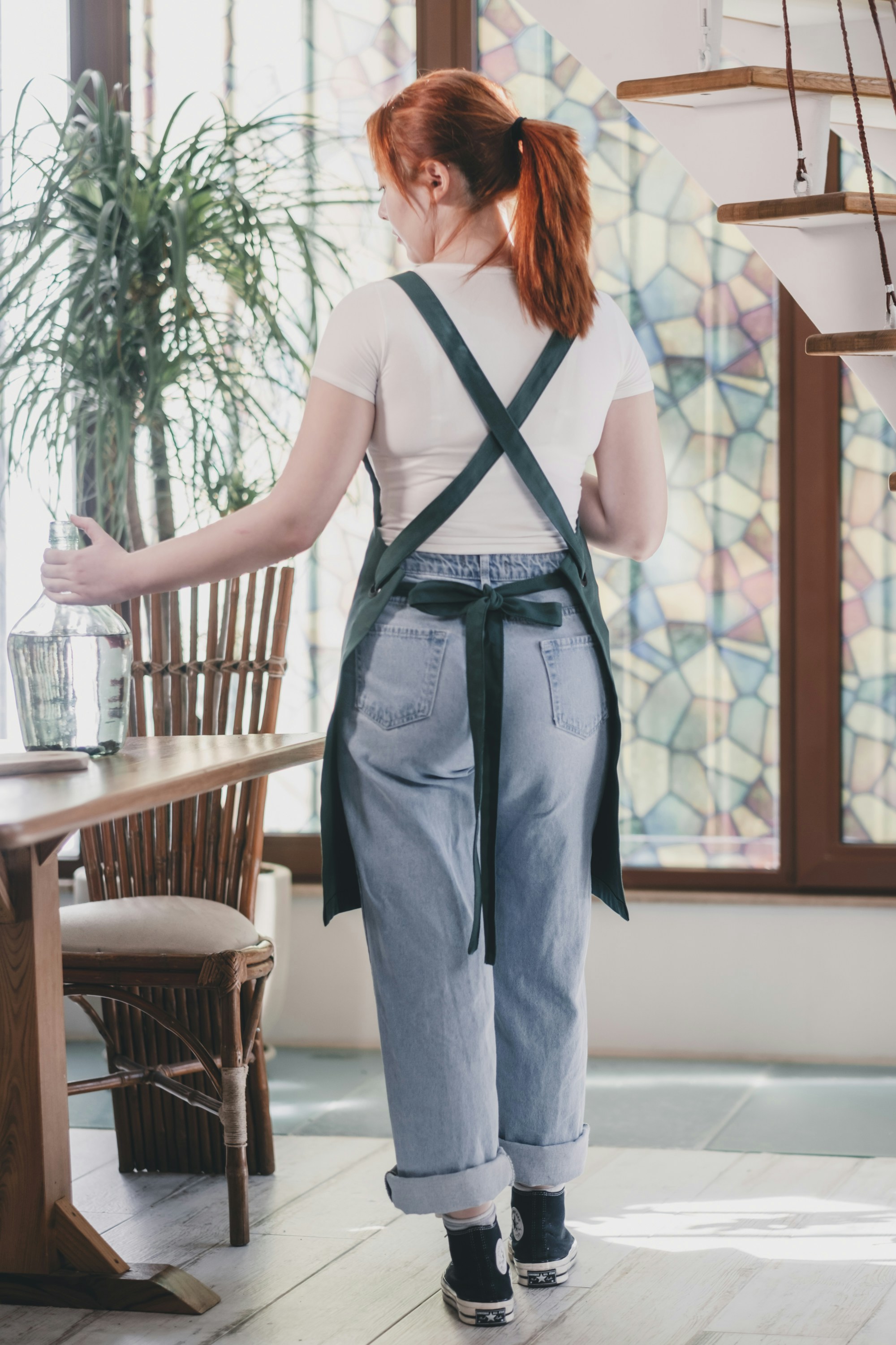 Eine Frau, die mit einem Glas in der Hand an einem Tisch steht
