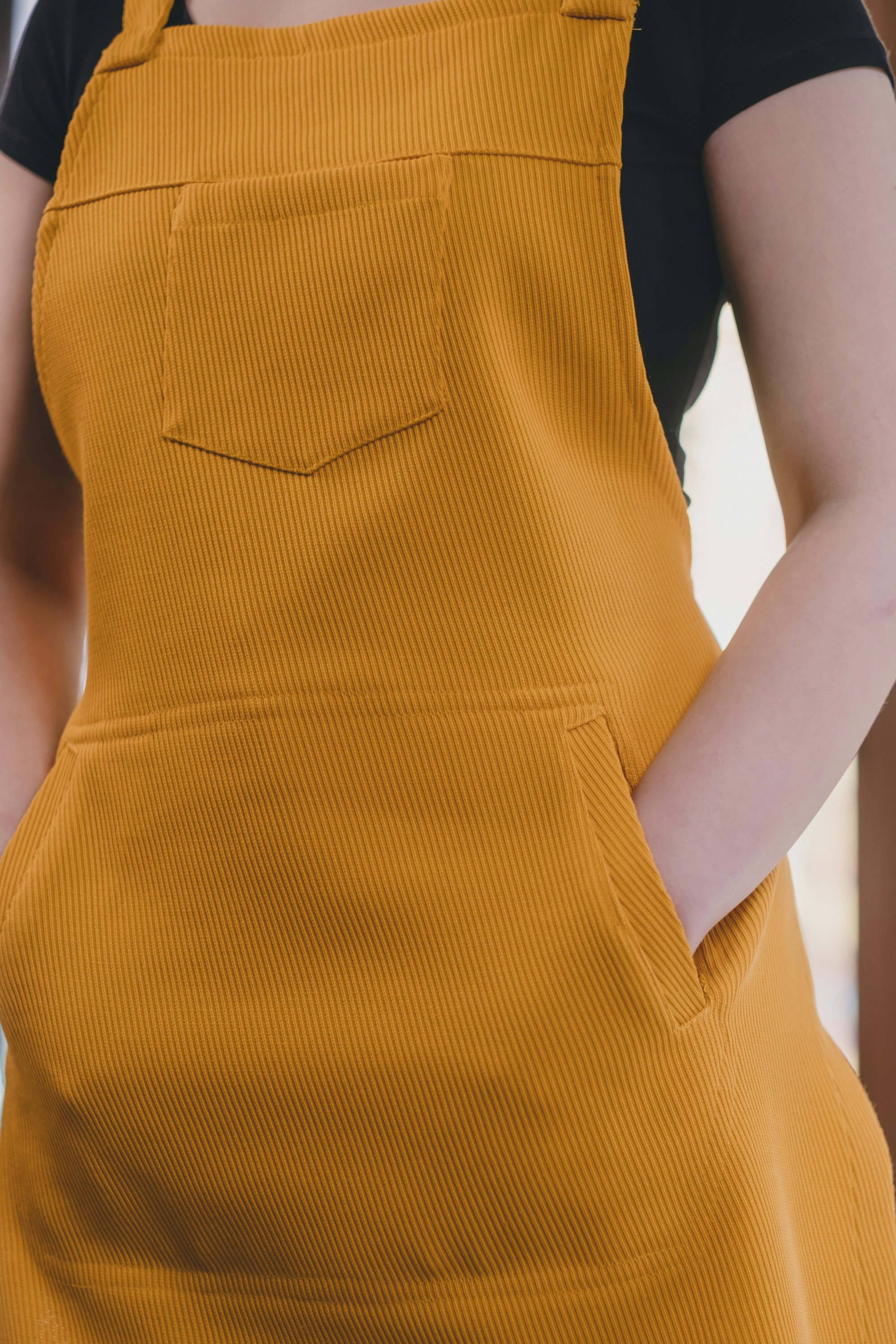 Eine Frau trägt eine orangefarbene Schürze und ein schwarzes Hemd