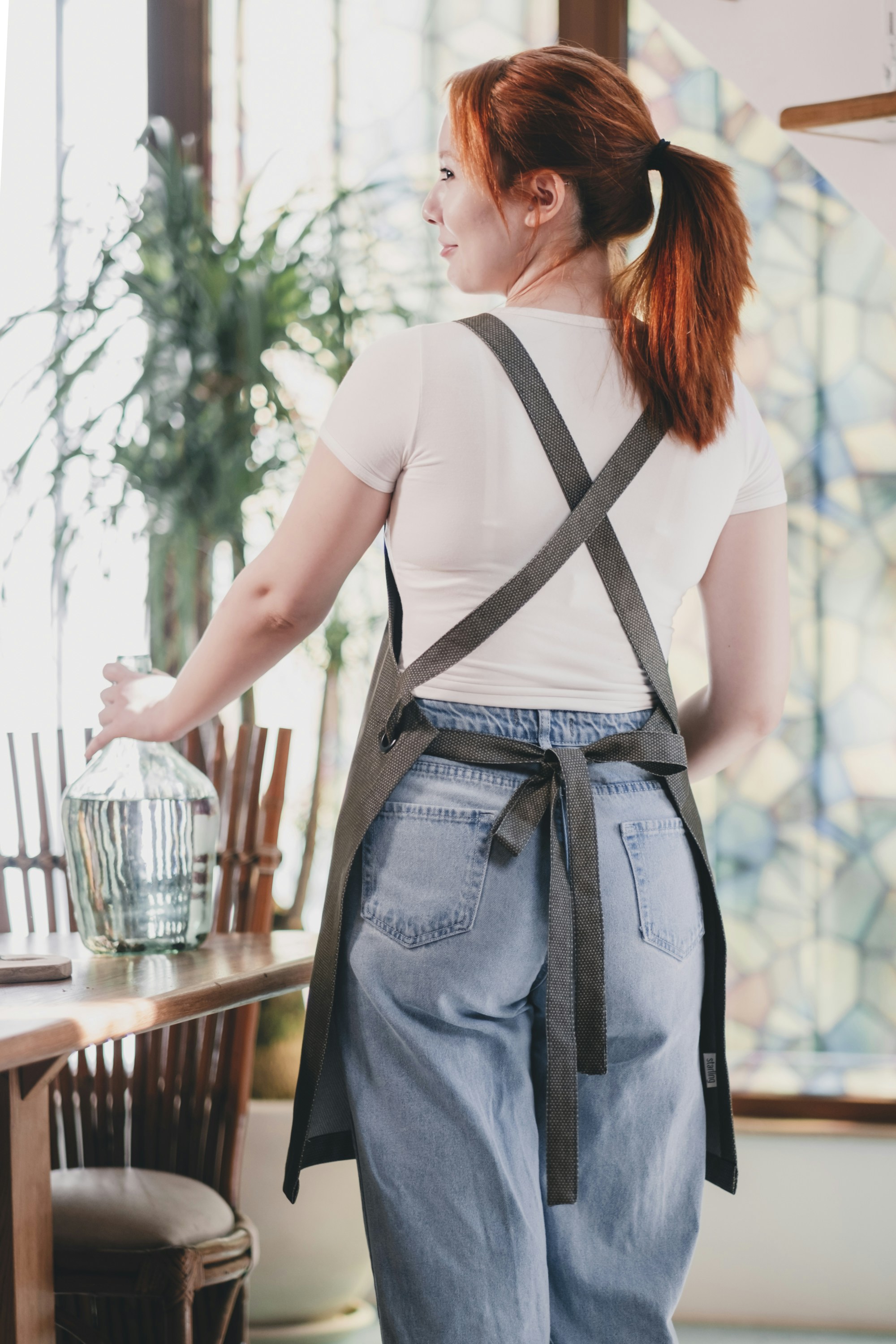 A woman standing in front of a wooden table