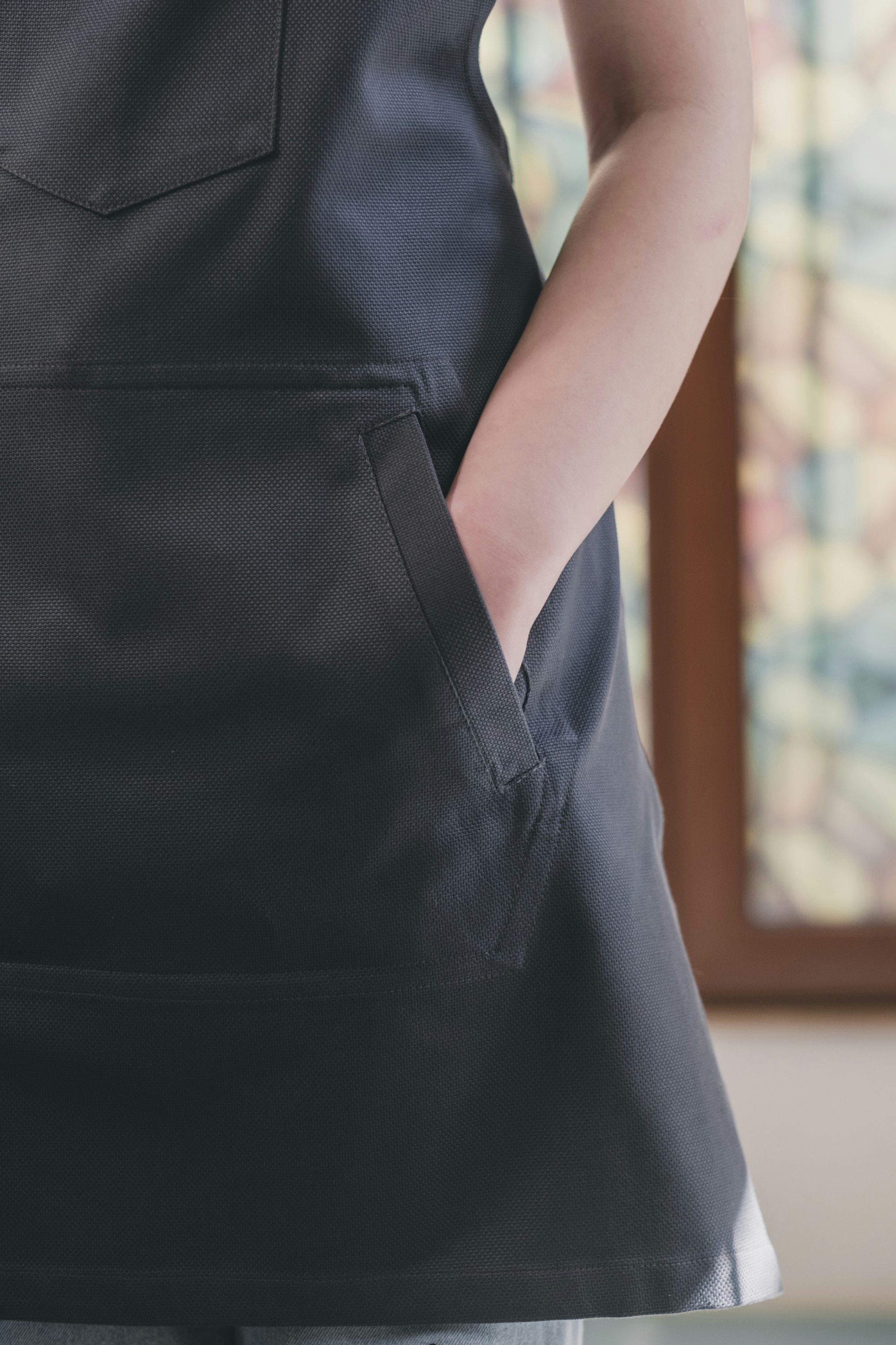 A woman wearing a black apron with a pocket