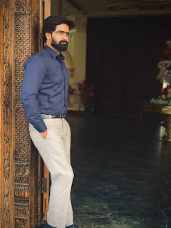 A man standing in a doorway with his hands in his pockets