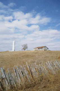 A house on a hill with a fence in front of it