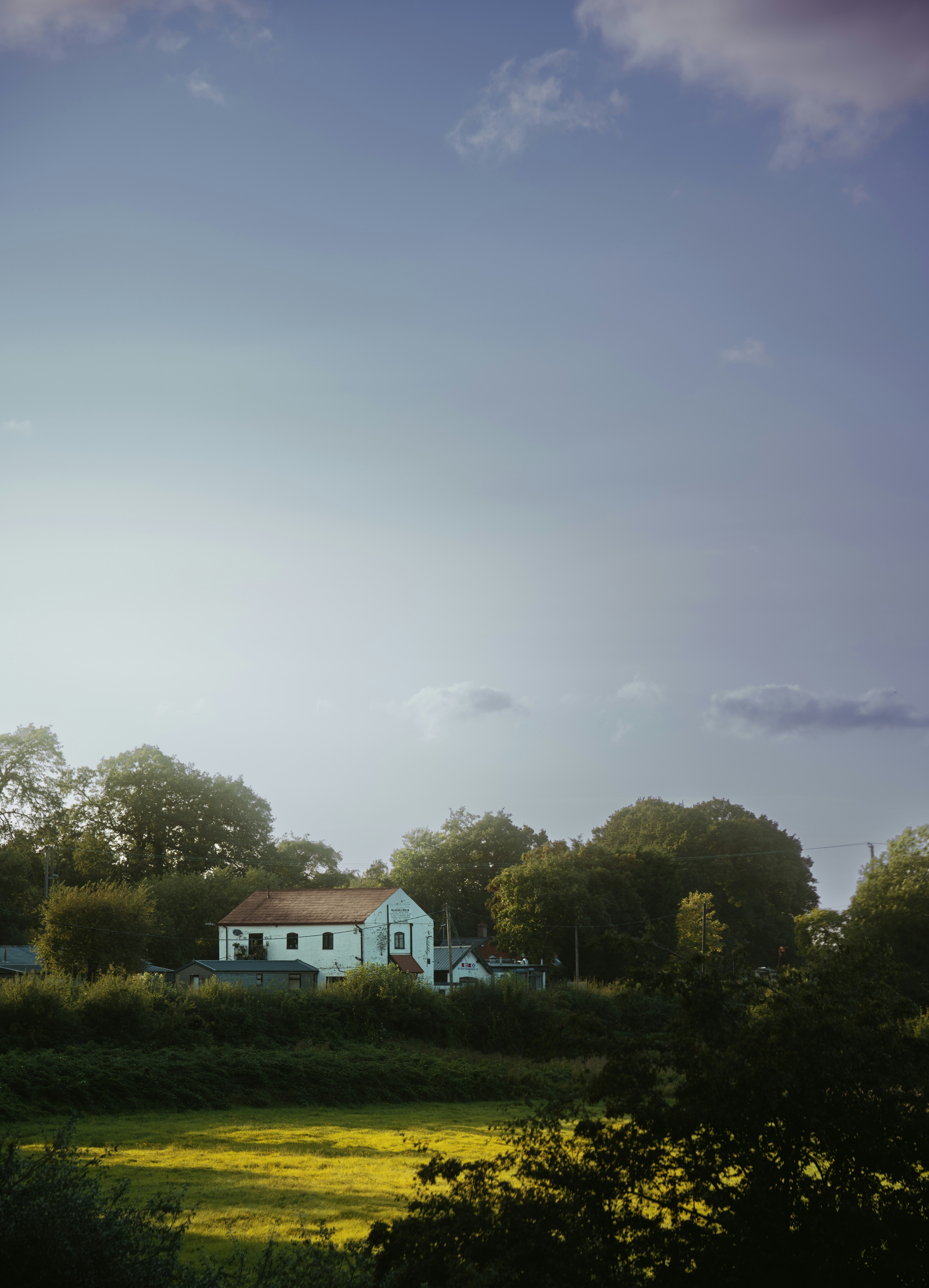 A large white house sitting on top of a lush green field