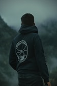 A man standing in front of a foggy mountain