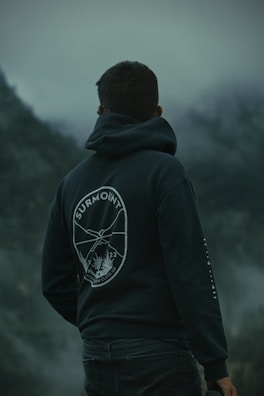 A man standing in front of a foggy mountain