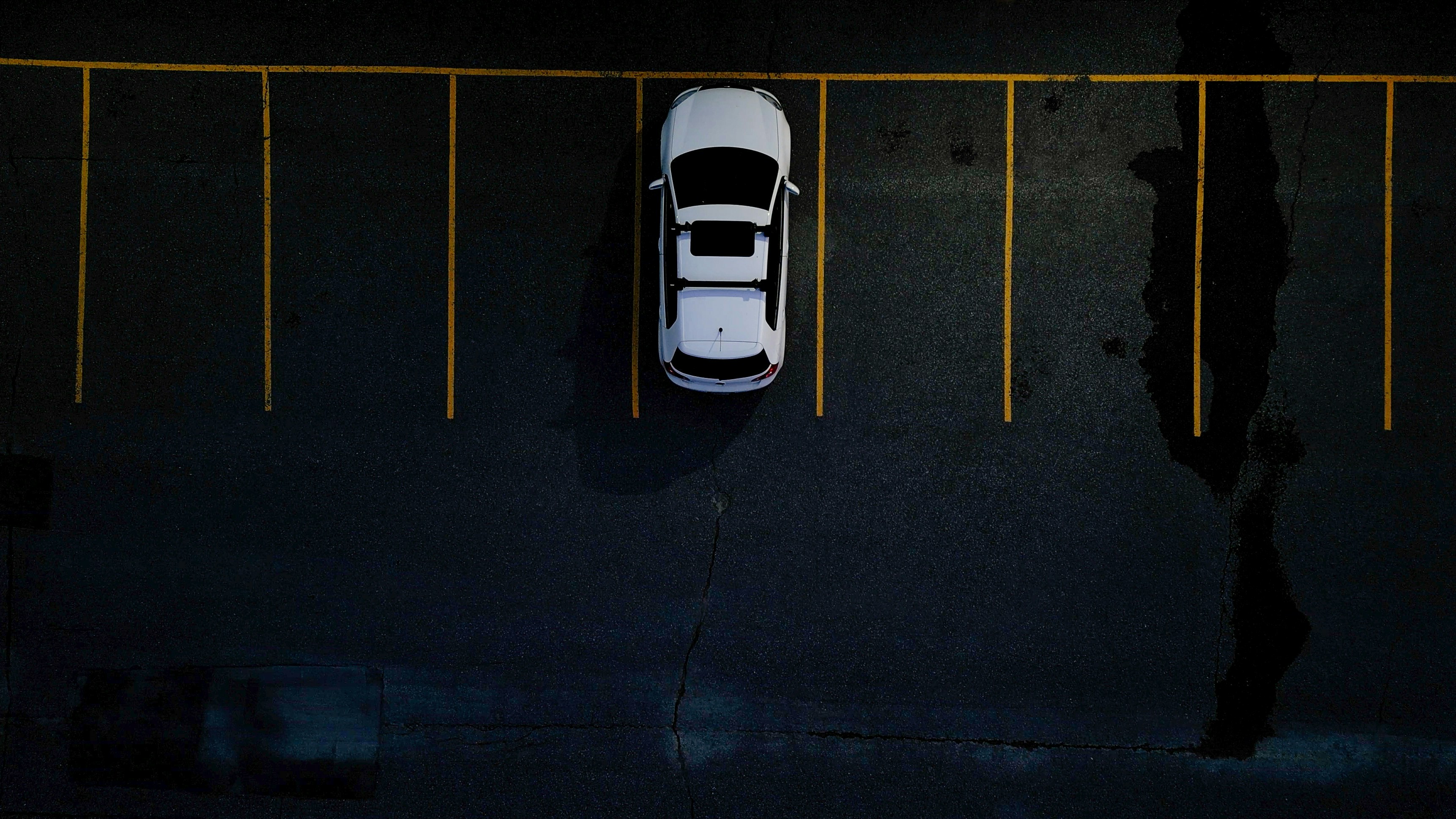 An overhead view of a car parked in a parking lot
