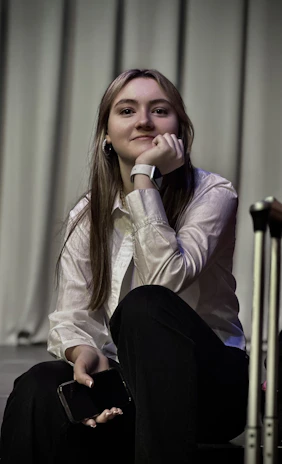 A woman sitting on the ground next to a suitcase