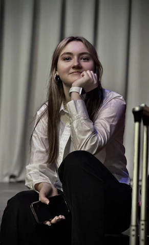 A woman sitting on the ground next to a suitcase