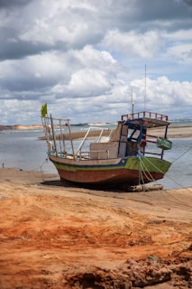 A boat sitting on top of a sandy beach