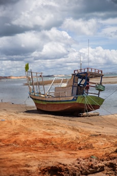 A boat sitting on top of a sandy beach