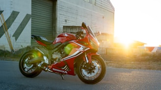 A red motorcycle parked in front of a building