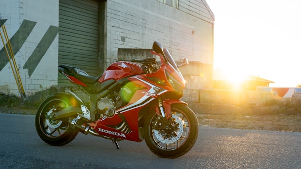 A red motorcycle parked in front of a building