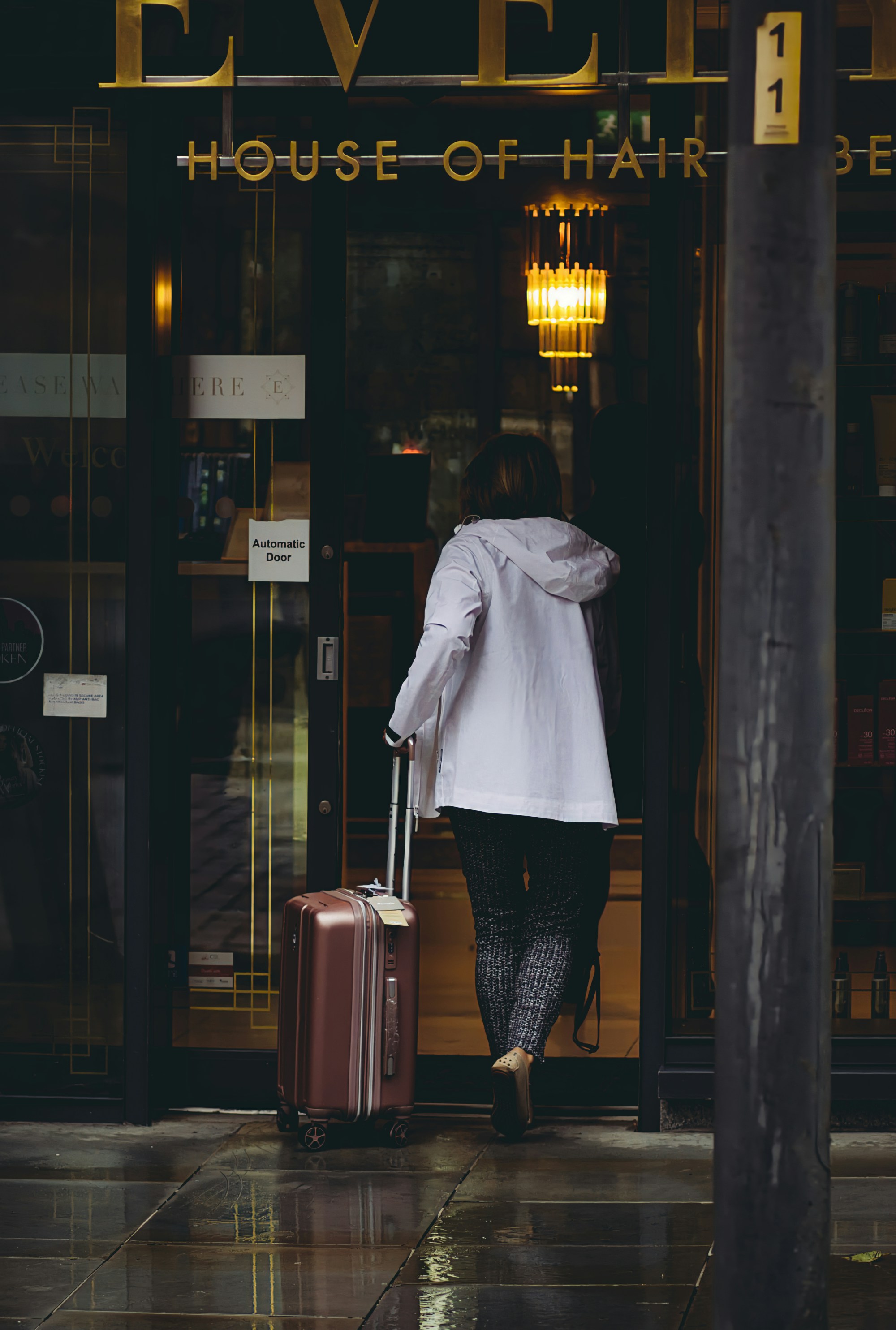 A stylish woman packing a minimalist suitcase with neutral-colored clothing, embodying the concept of traveling light.