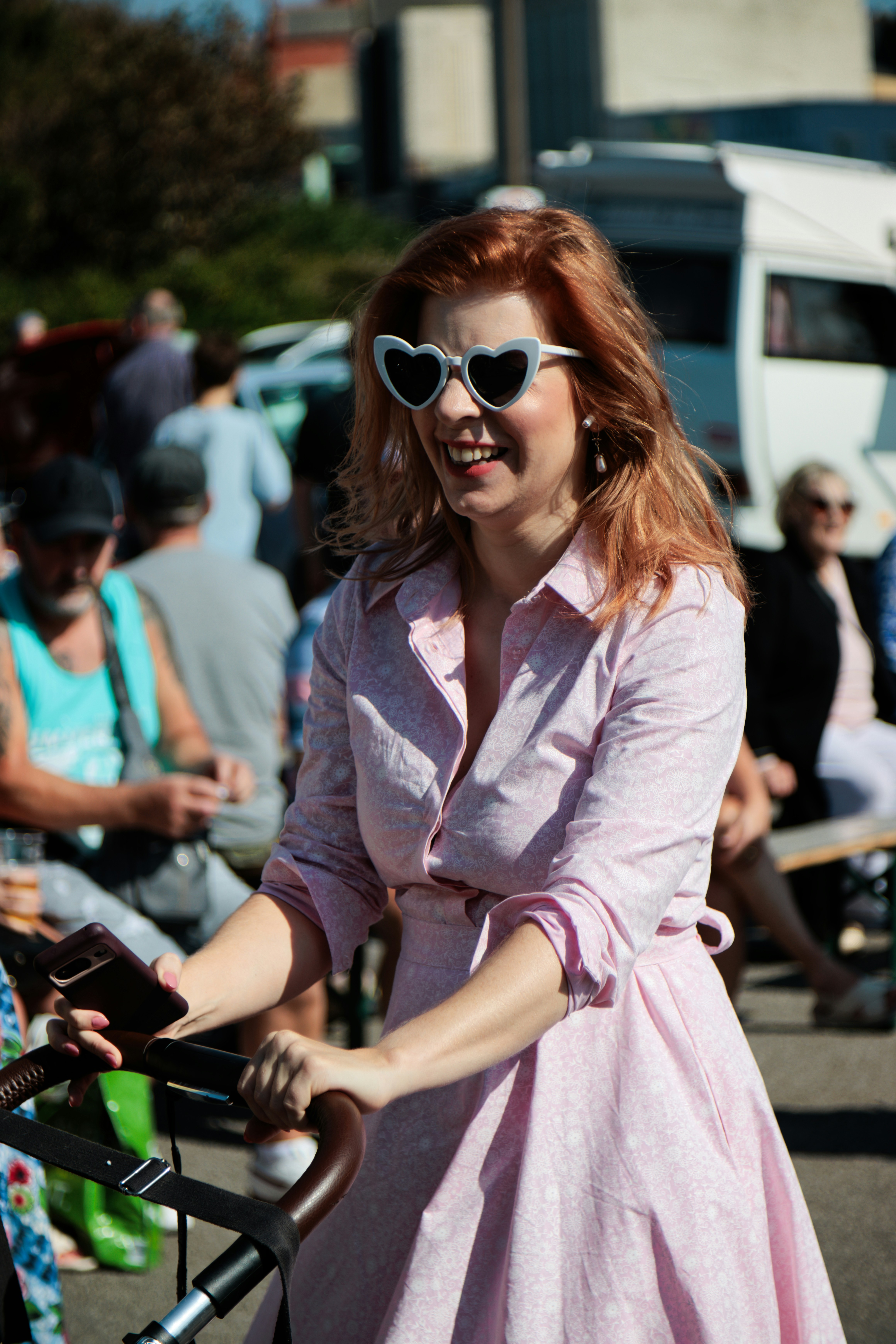 A woman in a pink dress riding a bike