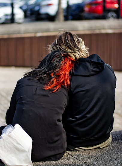 A person sitting on the ground with their back to the camera