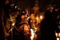 A group of people standing around a bunch of candles