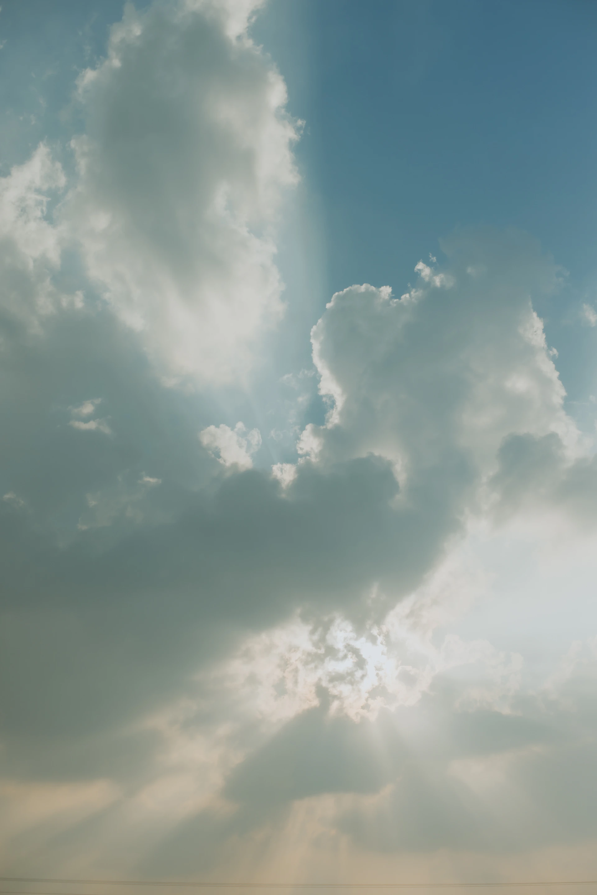 A plane flying through a cloudy blue sky