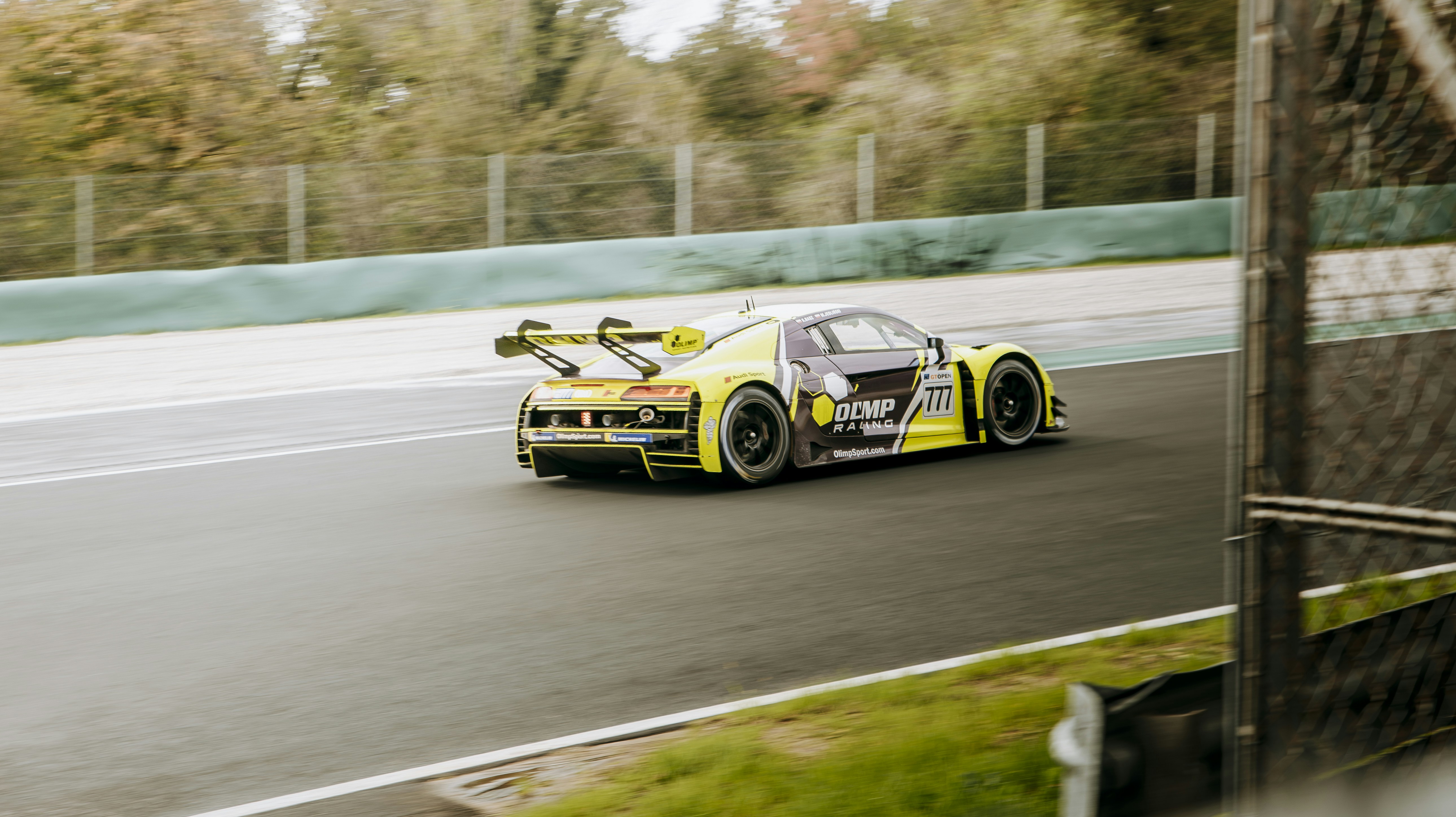 A yellow race car driving down a race track photo – Free Autodromo ...